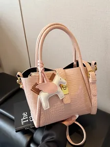 Borsa a secchiello rosa stampa coccodrillo con chiusura dorata e ciondolo cavallo