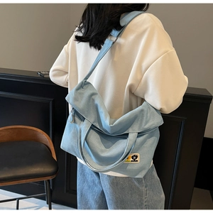 Detail shot of light blue canvas tote bag featuring vintage denim texture and cute cartoon patch