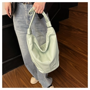 Détail du sac cabas vert menthe en cuir souple avec bandoulière nouée et texture brillante