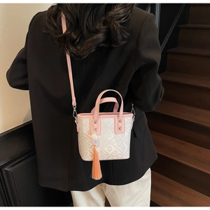 Détail du mini sac seau avec texture jacquard géométrique et lanières en cuir rose