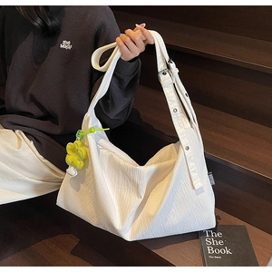 Detailed shot of white pleated tote bag with sunflower charm and adjustable strap