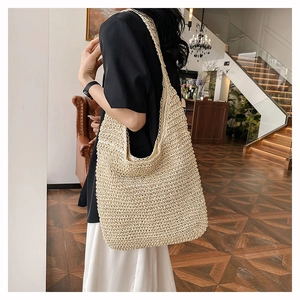 Close-up of beige woven straw tote bag featuring detailed hollow-out craftsmanship
