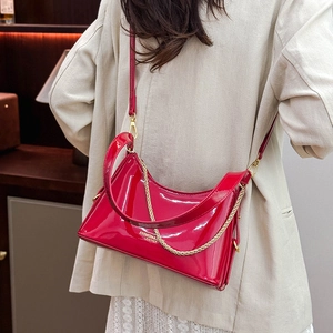 Detail of red patent leather hobo bag with gold chain strap and fashion lettering