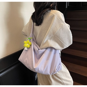 Detail of light purple hobo bag with wrinkled texture and yellow sunflower charm
