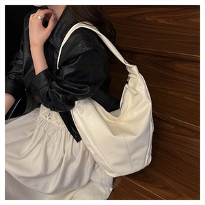 Sac hobo blanc crème chic au fini brillant présenté dans une scène de rue élégante et moderne