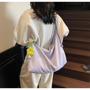 Detail of light purple large canvas tote bag with yellow sunflower charm on a person