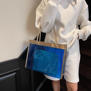 Blue transparent PVC tote bag with rope handles and inner pouch shown in a casual lifestyle setting