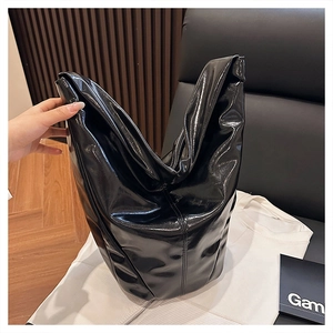 Gros plan d'un sac seau en cuir noir brillant avec une finition laquée et grande capacité