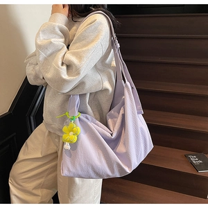Detail of lavender nylon tote bag with pleated texture and a yellow sunflower plush charm