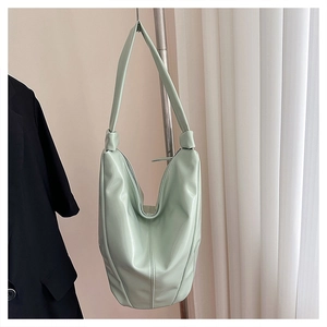 Détail du sac hobo vert menthe avec large bandoulière et finition en cuir verni brillant