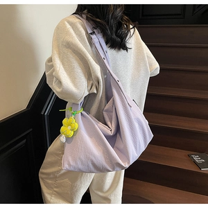 Detail of light purple tote bag with adjustable strap and yellow flower charm decoration