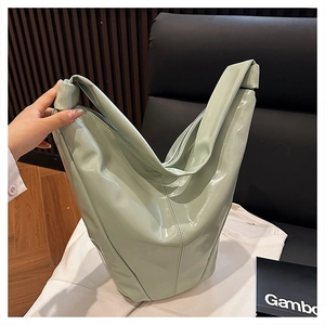 Détail du sac à bandoulière vert menthe en cuir verni brillant avec texture froissée