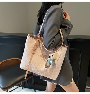 Détail du sac cabas rose à fleurs avec anses en cuir et porte-clés ours mignon