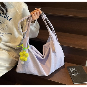 Detail of light purple large capacity nylon handbag with a yellow flower charm accessory