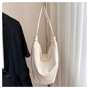 Détail du sac hobo en cuir souple crème avec bandoulière froncée et zip en argent