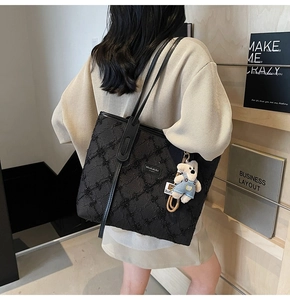 Détail du grand sac cabas noir à paillettes avec un pendentif d'ours en peluche