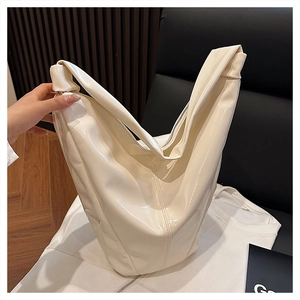 Détail du sac fourre-tout en cuir verni crème brillant avec couture centrale et bandoulière