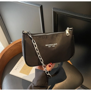 Detailed view of black nylon shoulder bag with silver chain and white logo text