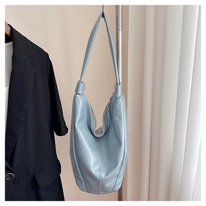 Sac seau en cuir souple bleu clair brillant avec des détails de nœuds sur le crochet