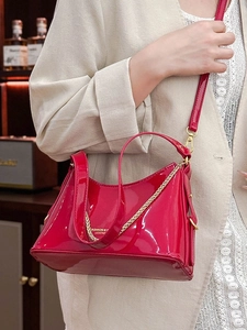 Large red patent leather bucket bag with gold chain and sleek polished finish