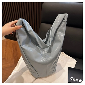 Gros plan sur le sac en cuir verni bleu clair avec une finition brillante et coutures