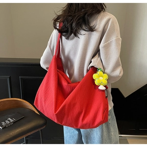 Macro detail of red nylon hobo bag texture and yellow plush sunflower charm accessory