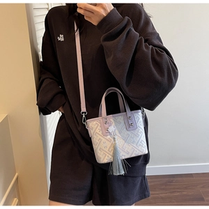 Détail du mini sac seau lavande avec motif jacquard géométrique et breloque à long pompon