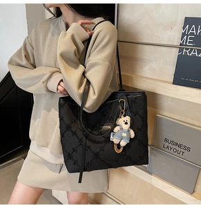 Détail du sac cabas noir texturé avec logo MashaKeke et charmant petit ours bleu