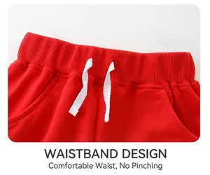 Detail of red kids' shorts featuring elastic waistband with white decorative drawstrings