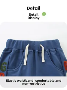 Detail of elastic waistband with white drawstring and colorful letter embroidery on shorts