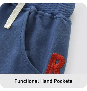 Detail of blue cotton shorts featuring premium R embroidery and ribbed elastic waistband