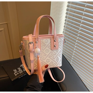 Détail du sac seau rose et blanc à motif floral avec pompon et boucles argentées