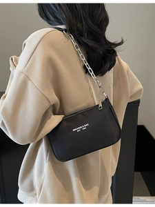 Fashionable black nylon shoulder bag with silver chain strap and white artistic logo text
