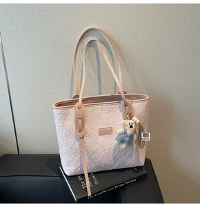 Détail du sac cabas jacquard floral avec anses en cuir et un pendentif ours en peluche