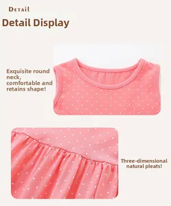 Detail view of pink polka dot cotton dress showing round neckline and pleated texture