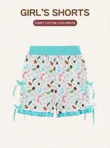 Detail of girls' cotton shorts with animal prints, blue bows, and ruffle hem accents