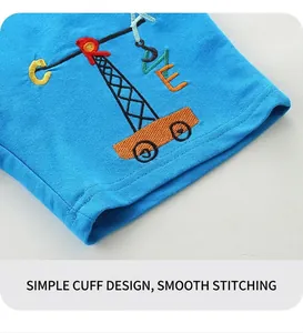 Dettaglio di pantaloncini in cotone blu con ricamo di gru a cartone animato e scritta LOVE