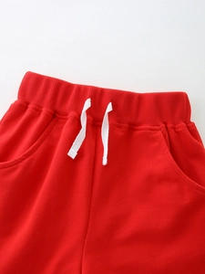 Boy's red cotton shorts featuring an adjustable drawstring and comfortable elastic waistband