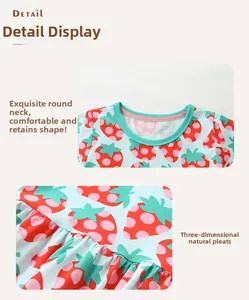 Détail d'une robe d'été pour fille avec imprimé fraise, col rond vert et ourlet plissé