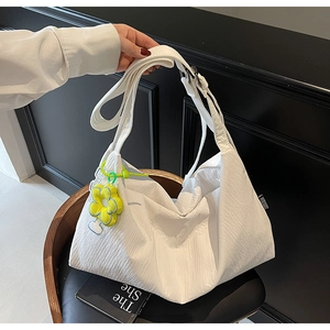 Detail showing white pleated texture fabric handbag with a yellow flower charm