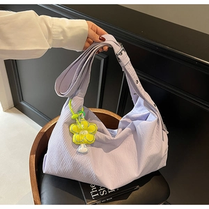 Detail of light purple nylon hobo bag with yellow flower charm and adjustable strap
