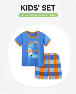 Detail of blue cotton T-shirt with crocodile print and matching plaid shorts for boys