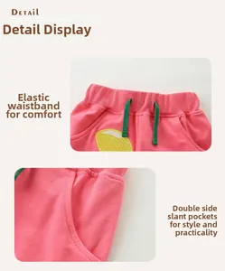 Détail du short rose avec taille élastique, cordon vert et broderie citron en coton
