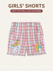 Détail d'un short rose à carreaux en coton pour filles avec broderie licorne et volants doux