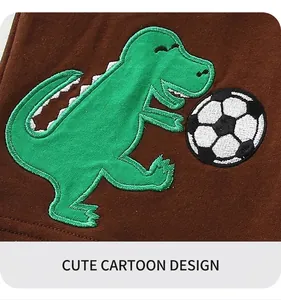 Détail de la broderie dinosaure vert sur un short en coton marron foncé pour garçon