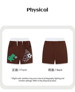 Détail de la broderie dinosaure et des motifs football sur le short en coton marron garçon