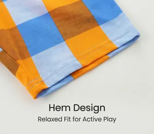 Detail of loose hem with colorful orange and blue plaid pattern on boy's shorts