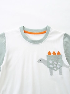 Kids cotton t-shirt featuring dinosaur embroidery and functional pocket with orange 3D details