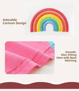 Détail de la broderie arc-en-ciel sur robe en coton rose avec coutures surjetées