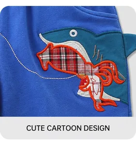 Detail of shark embroidery with red and black plaid pattern on blue cotton shorts